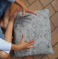 Child's hands with coins on a pillow