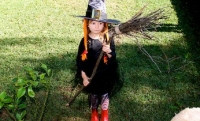 Girl dressed as witch with broomstick on Kidspot