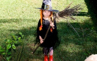 Girl dressed as witch with broomstick on Kidspot