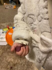Baby hand holding a little bellies snack ball. 
