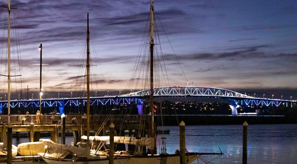 Auckland Harbour Bridge lit up in the dusk. 