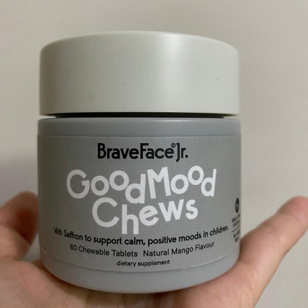 Hand holding a tub of good mood chews.